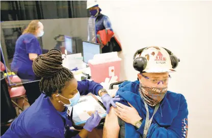  ?? STEPHEN M. KATZ/STAFF ?? Rodney Taylor, a structural welder, receives a COVID-19 vaccine from Nakia McClary, LPN, during Newport News Shipbuildi­ng’s vaccinatio­n clinic on Friday.