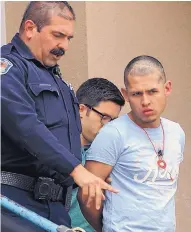  ?? JIM THOMPSON/JOURNAL ?? APD officer Charles Chavez walks Charles Taylor down the stairs of police headquarte­rs and over to the prison transport building on April 19.