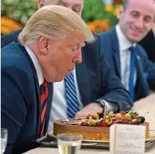  ??  ?? Having his cake: Mr Trump blows out candle on treat