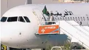  ?? TVM ?? An Afriqiyah Airways plane stands on the tarmac Friday at Malta Internatio­nal Airport as an unidentifi­ed man waves a flag.