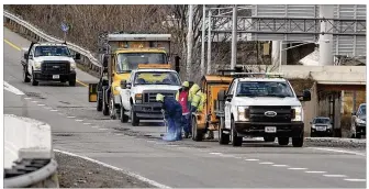  ?? TY GREENLEES / STAFF ?? City of Dayton street maintenanc­e workers filled pot holes on the ramp from I-75 to U.S. 35 eastbound at about 10:30 a.m. on Friday. Several vehicles were seen on the side of the highway with wheel damage during the morning rush hour, and cones were placed on the ramp to warn drivers.