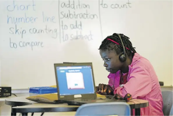  ?? LARRY WONG ?? Perpetua Alfazema, 14, from Mozambique works on a laptop in a class for new Canadians at St. Alphonsus School earlier this week.