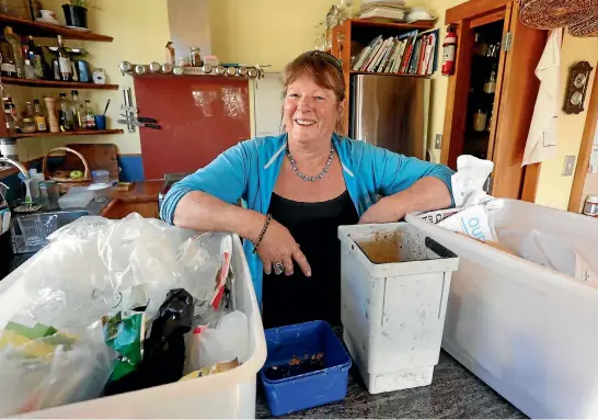  ?? MARTIN DE RUYTER/STUFF ?? Sue Ware with her plastic recycling bin, left, food scraps for her chickens container, compost bin and paper recycling bin in the kitchen of her Nelson home. The kitchen is made from recycled timber. Her family produce only a bag of rubbish every six...