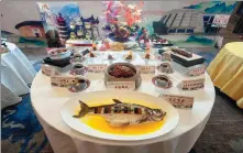  ?? PHOTOS PROVIDED TO CHINA DAILY ?? Left: A table of Hakka dishes presented by one of the eight master chef teams during the “Longyan welcomes the Year of the Loong” Hakka cuisine exchange held in Longyan, Fujian province, on Jan 17. Right: Chef Chen Zehuan.