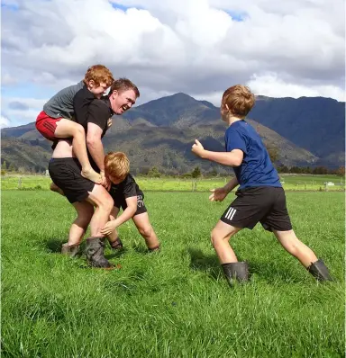  ??  ?? Opposite page: Husband-and-wife dairy farmers Wayne and Tyler Langford, with their three young sons Alfie, Lewis and Gordie. This page: Wayne enjoys a game of backyard footy with his boys, one of the daily activities that allows him to say he has ‘lived’ for that day.