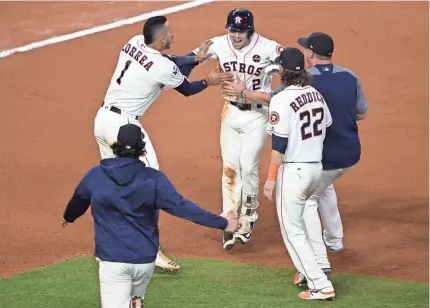  ??  ?? Houston’s Alex Bregman (2) celebrates with teammates after hitting the game-winning RBI single in the 10th inning to beat Los Angeles 13-12 in Game 5 Sunday night. SHANNA LOCKWOOD, USA TODAY SPORTS