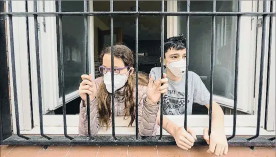  ?? JORDI ROIG ?? Imagen de unos niños mirando hacia la calle desde la ventana del comedor de su casa en Igualada