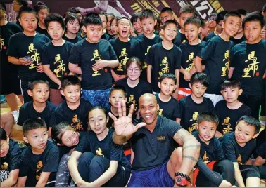  ?? PROVIDED TO CHINA DAILY ?? Former NBA All-Star Stephon Marbury, co-founder and head coach of the new Stronger Me Basketball Training Camp, poses with young players at Sunday’s launch in Beijing.