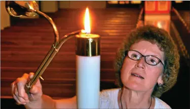  ?? MEDIANEWS GROUP FILE PHOTO ?? Rev. Dr. Sue Bertolette lights a candle on the altar at St John’s United Church of Christ as she prepares for a Sunday service in 2012.