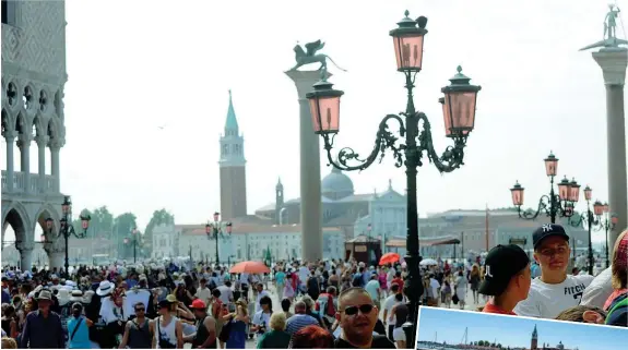  ?? (Foto LaPresse) ?? Piazza San Marco Turisti nel centro di Venezia davanti alle colonne di San Marco e San Todaro