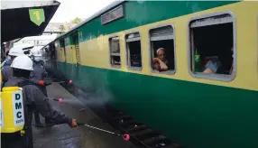  ?? AN photo by S.A. Babar ?? Railway staff fumigating a train in Karachi, where 34 lines have been suspended due to new lockdown measures introduced to stop the spread of the coronaviru­s.