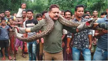  ?? AFP ?? Forest range officer Sanjay Dutta holds a 30-foot long python weighing 40 kg at Sahebbari village in Jalpaiguri district, West Bengal, on Sunday.