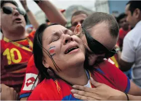  ?? YASUYOSHI CHIBA/AFP/Getty Images ?? Costa Rican fans react after their team’s 1-0 victory as they watch a telecast on a large
screen in Rio de Janeiro on Friday of the Group D match against Italy.
