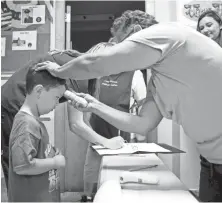  ?? RACHEL DENNY CLOW/CALLER-TIMES ?? Jayden Herrera, 4, has his temperatur­e checked as he arrives at a Corpus Christi, Texas, daycare center March 19. Schools may be asked to check temperatur­es of students and staff daily when they reopen.