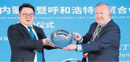  ??  ?? MengTai vicechairm­an Ao Bo and Angus businessma­n Dave Valentine holding a quaich inscribed with the message “Together we will make the dream a reality”.