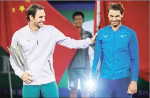  ?? NICOLAS ASFOURI/ AFP ?? Winner Roger Federer (left) and Rafael Nadal joke after the men’s singles final at the Shanghai Masters yesterday.