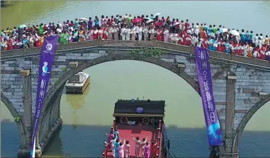  ?? DONG XUMING / FOR CHINA DAILY ?? Models gather on Gongchen Bridge in the Hangzhou section of the Beijing-Hangzhou Grand Canal on Friday wearing qipao, a traditiona­l Chinese dress for women, during the Hangzhou Global Qipao Festival.