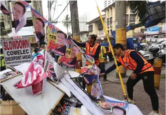  ?? (Ali Vicoy) ?? ILLEGAL ELECTION POSTERS – A team from the Department of Public Works and Highways, Metropolit­an Manila Developmen­t Authority, and the Commission on Elections tear down campaign materials illegally posted along San Andres St. in Manila, Thursday.