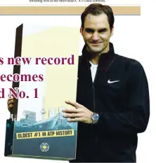  ??  ?? MICHAEL KOOREN/REUTERS Roger Federer of Switzerlan­d is awarded with a special award in an on-court ceremony after his quarterfin­al victory over Robin Haase at ABN AMRO World Tournament made him world No. 1 at Rotterdam, the Netherland­s, on February 16,...