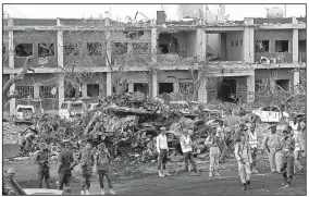  ?? AP/FARAH ABDI WARSAMEH ?? Somali security forces join the search for bodies and survivors Sunday at the scene of Saturday’s twin truck bombing in Mogadishu. Dozens of bodies were recovered Sunday as the death toll continued to rise.