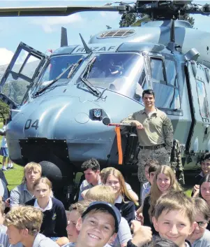  ?? PHOTO: SIMON HENDERSON ?? High flyer . . . Flight Lieutenant Tom McDowell treats Cromwell College pupils to a visit by the Royal New Zealand Air Force NH90 helicopter he captains.