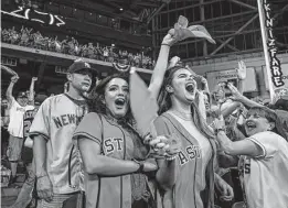  ?? Godofredo A. Vásquez / Staff photograph­er ?? Krystianna Guerra and Larissa
Oswald celebrate Yuli Gurriel’s three-run home run during the first inning of Game 6 on Saturday at Minute Maid Park. The Astros defeated the Yankees 6-4 on Jose Altuve’s ninth-inning home run to advance to the World Series.