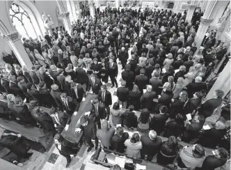  ?? Todd McInturf/Associated Press ?? Family and friends stand as the casket is processed after the funeral of Brian Fraser. Fraser was identified as one of three students slain during a mass shooting on the Michigan State campus.