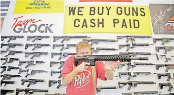  ??  ?? A worker inspects an AR-15 gun.