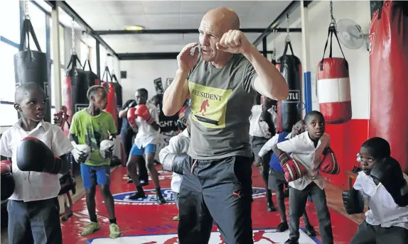  ?? Picture: RAYMOND PRESTON ?? WORK IT OUT: Anton Gilmore shows street kids the ropes in a boxing gym in Hillbrow