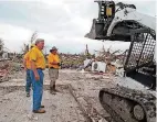  ?? [PHOTO BY CARLA HINTON, THE OKLAHOMAN] ?? Sam Porter looks on as a Southern Baptist Disaster Relief team from North Carolina moves debris in the Plaza Towers housing addition in Moore after a tornado on May 20, 2013.