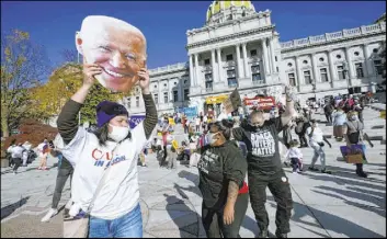  ?? Julio Cortez The Associated Press ?? People dance in celebratio­n Saturday outside the Pennsylvan­ia State Capitol in Harrisburg after Democrat Joe Biden, who was born in the state, defeated President Donald Trump in the race for president of the United States.
