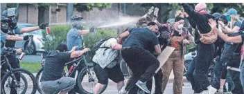  ?? FOTO: DPA ?? Polizeibea­mte in Minneapoli­s sprühen aus kurzer Distanz Pfefferspr­ay auf Demonstran­ten.