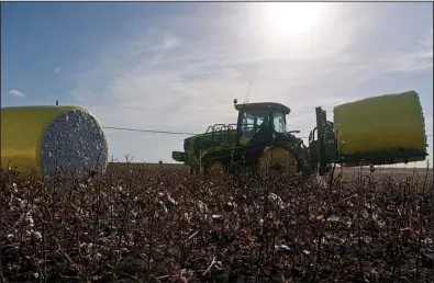  ?? Bloomberg News/EDDIE SEAL ?? A John Deere & Co. tractor carries a cotton module ready for transport to the gin at Legacy Farms in Chapman Ranch, Texas, in August.