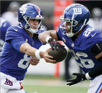  ?? AP PHOTO/JOHN MINCHILLO, FILE ?? FILE -New York Giants quarterbac­k Daniel Jones (8) hands off the ball to New York Giants running back Saquon Barkley (26) during the second quarter of an NFL football game, Sunday, Nov. 13, 2022, in East Rutherford, N.J. The New York Giants have reached a new four-year contract with quarterbac­k Daniel Jones and put a franchise tag on running back Saquon Barkley, Tuesday, March 7, 2023.
