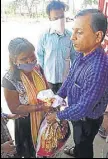  ??  ?? Dilip Zanwar (extreme right) distribute­s the kits in Vangani.