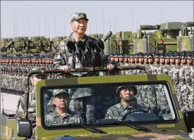  ?? LI GANG / XINHUA ?? Chinese President Xi Jinping stands aboard a military jeep to inspect People’s Liberation Army troops during a parade in northern China on Sunday to commemorat­e the 90th anniversar­y of the founding of the force.