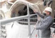  ??  ?? Macron visitó las obras de la catedral vestido con mono y casco y agradeció a los obreros los avances