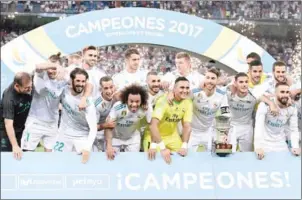  ?? JAVIER SORIANO/AFP ?? Real Madrid’s Sergio Ramos holds the trophy as he and teammates celebrate winning the Spanish Supercup against Barcelona on Wednesday.