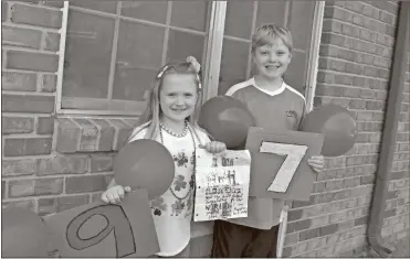  ?? Contribute­d ?? Mary Grace and Benji Drummond help celebrate their great-grandfathe­r’s birthday with balloons and signs outside his window Tuesday at a local healthcare facility.