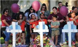  ?? Photograph: Michael M Santiago/Getty Images ?? People visit memorials for victims of Tuesday's mass shooting at an elementary school in Uvalde, Texas.