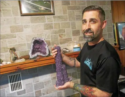  ?? PHOTO SPECIAL TO THE DISPATCH BY MIKE JAQUAYS ?? Michael Eggleston of Hamilton shows a purple Amethyst stalactite from Bolivia at his InnerVisio­n Crystals display room Wednesday.