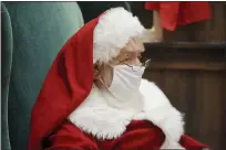  ?? BEN HASTY — MEDIANEWS GROUP ?? Santa Claus sits in a big chair while wearing a face mask at the Berkshire Mall Center court in Wyomissing. His smile is hidden by a mask he wears as a precaution against the spread of the COVID-19.