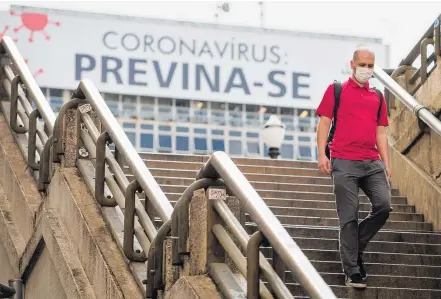  ?? TIAGO QUEIROZ / ESTADÃO ?? Proteção. Homem com máscara desce a escadaria do Viaduto do Chá, em São Paulo: governo alerta para falta do material