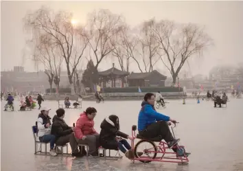  ?? — AFP ?? People enjoy riding on the ice of the Houhai frozen lake ahead of the Lunar New Year in Beijing on Wednesday. The Lunar New Year, known locally as the Spring Festival, falls on January 28 this year and marks the Year of the Rooster in the Chinese...