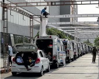  ?? AP ?? Ambulances carrying Covid-19 patients wait for their turn to be attended outside a government hospital in Ahmedabad as a worker erects a sun shade.