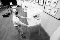  ?? RICARDO RAMIREZ BUXEDA/ORLANDO SENTINEL ?? Giovanny Quero, employee of the Orange County Supervisor of Elections, sets up voting booths for early voting in the Community Room of the Winter Park Public Library on July 30. Early voting runs to Aug. 16 from 9 a.m. to 7 p.m. at 18 Orange County locations.