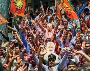  ??  ?? CELEBRATIO­N TIME BJP workers exult outside the party office in Bengaluru as results come in