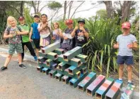 ??  ?? Mangonui School children with the pest monitoring tunnels they made for Rangikapit­i last year.