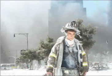  ?? ANTHONY CORREIA/GETTY IMAGES NORTH AMERICA/AFP ?? A New York City firefighte­r walks away from Ground Zero after the collapse of the Twin Towers on September 11, 2001, in New York City.