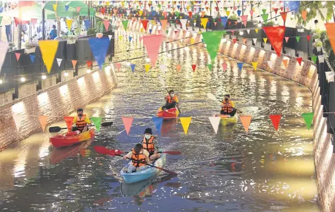  ?? PATTARAPON­G CHATPATTAR­ASILL ?? Boating bliss
Tourists kayak along Bangkok’s Ong Ang canal, which is decorated with colourful flags and lanterns to brighten the mood for residents. The weekend market nearby was reopened yesterday, and people can visit Friday to Sunday from 3-8pm.